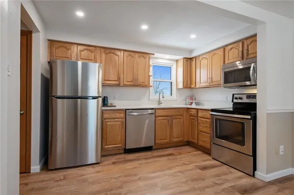 a kitchen with a refrigerator sink and cabinets