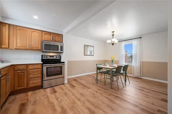 a kitchen with stainless steel appliances wooden floor dining table and chairs