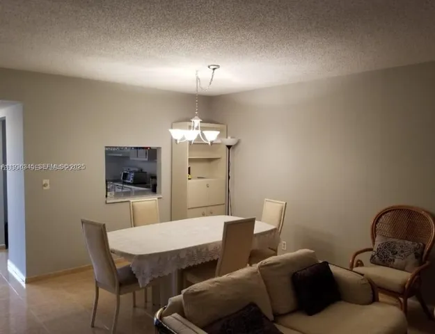 a living room with furniture a chandelier and a flat screen tv