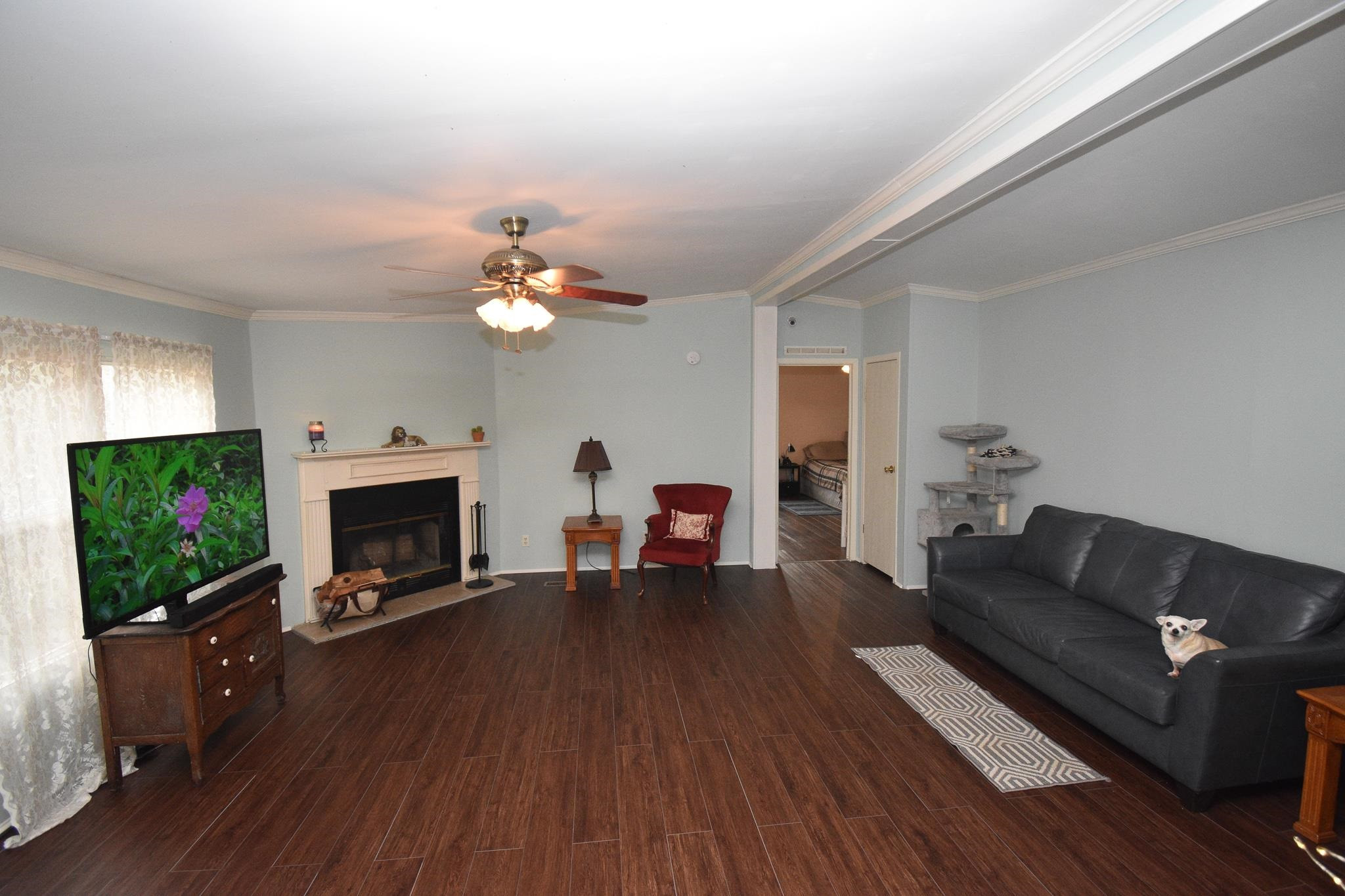 8484 Creek Road Willow Spring, NC 27592 - Photo 4 of 33 a living room with furniture a flat screen tv and a fireplace