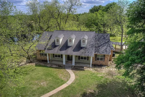 an aerial view of a house with a yard table and chairs