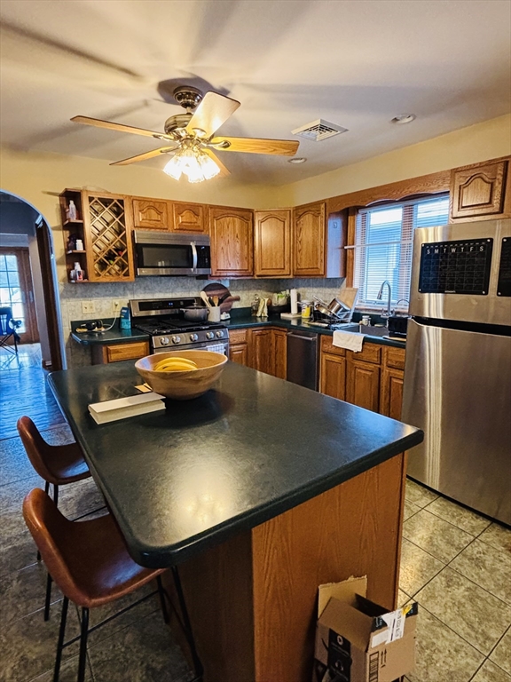 24 Meacham Street, Unit 2 Somerville, MA 02145 - Photo 7 of 11 a kitchen with sink a refrigerator and chairs