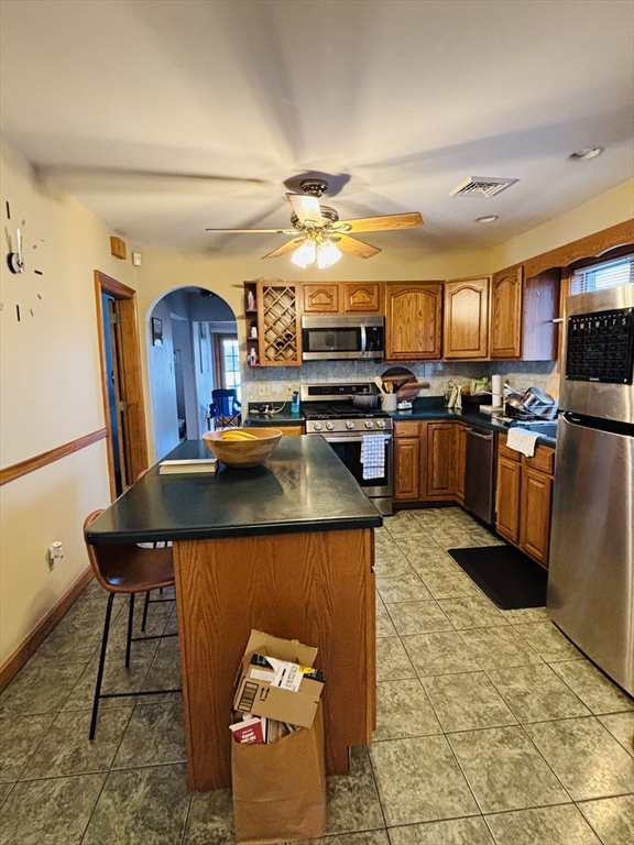 24 Meacham Street, Unit 2 Somerville, MA 02145 - Photo 8 of 11 a kitchen with kitchen island granite countertop wooden cabinets a dining table and chairs
