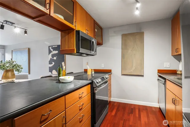 a kitchen with stainless steel appliances granite countertop a sink a stove and cabinets