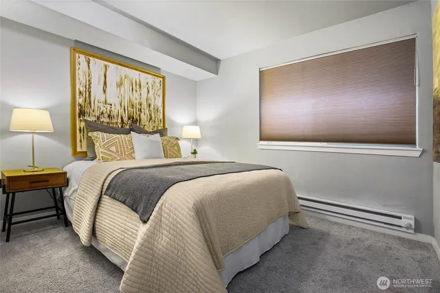 a bedroom with a bed and a lamp next to a window