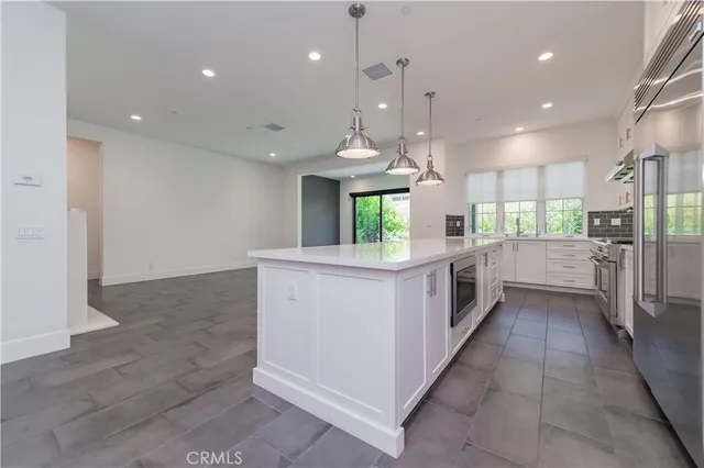 a kitchen with stainless steel appliances kitchen island a refrigerator sink and stove