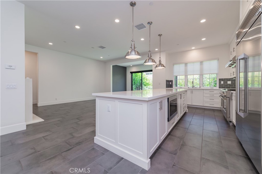 91 Rockinghorse Irvine, CA 92602 - Photo 13 of 48 a kitchen with stainless steel appliances kitchen island a refrigerator sink and stove