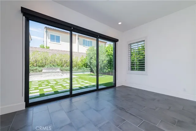 a view of an empty room with wooden floor and windows