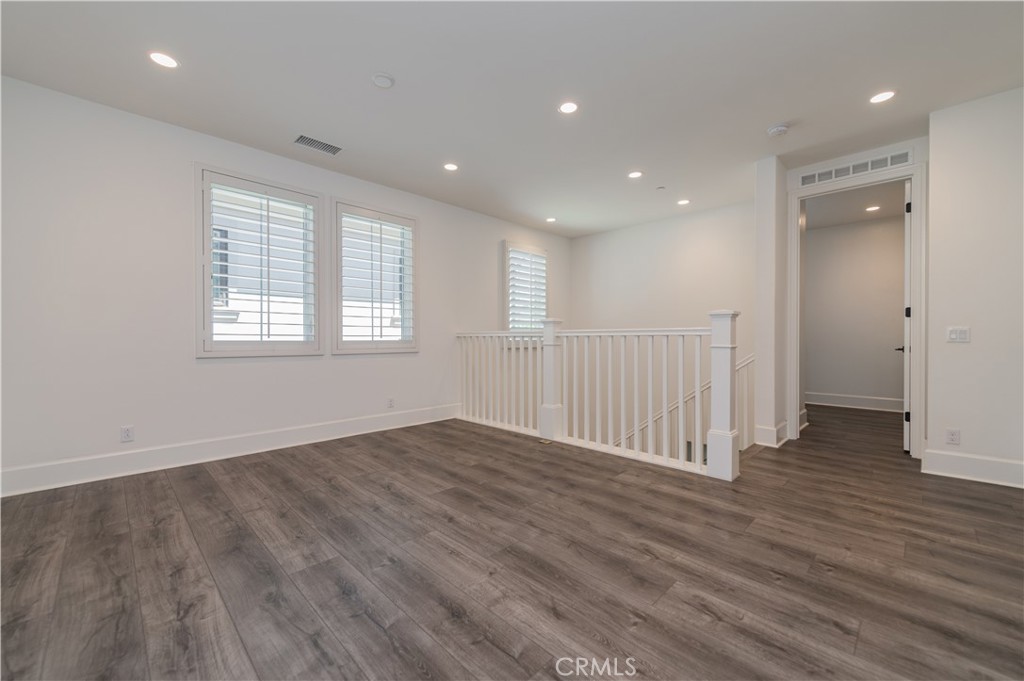 91 Rockinghorse Irvine, CA 92602 - Photo 24 of 48 an empty room with wooden floor and windows