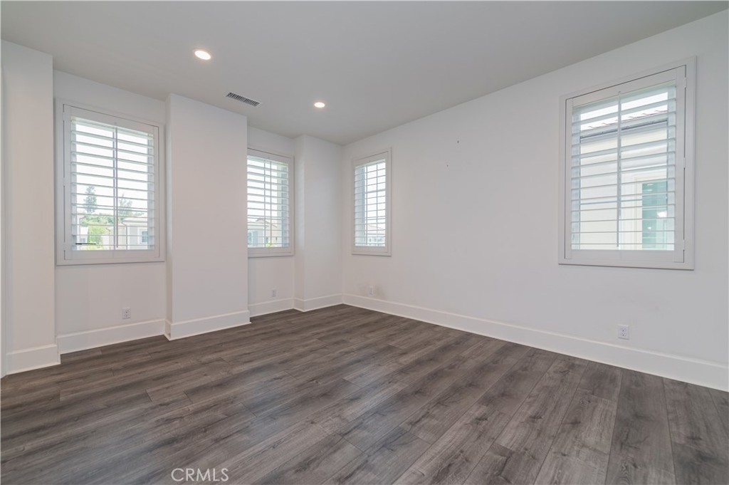 91 Rockinghorse Irvine, CA 92602 - Photo 27 of 48 an empty room with wooden floor and windows