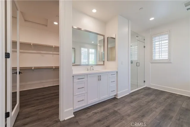 a bathroom with a double vanity sink a mirror and a shower