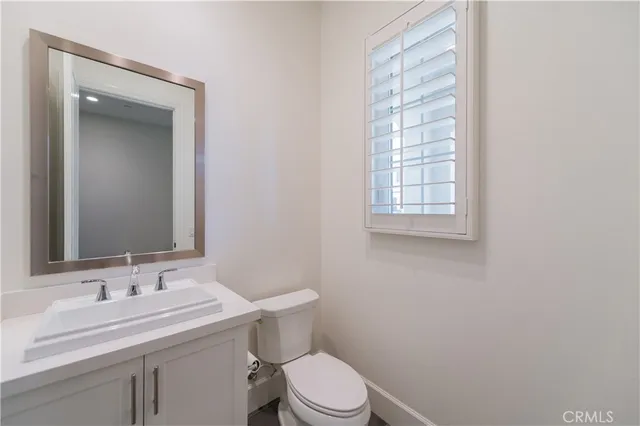 a bathroom with a granite countertop sink toilet and mirror