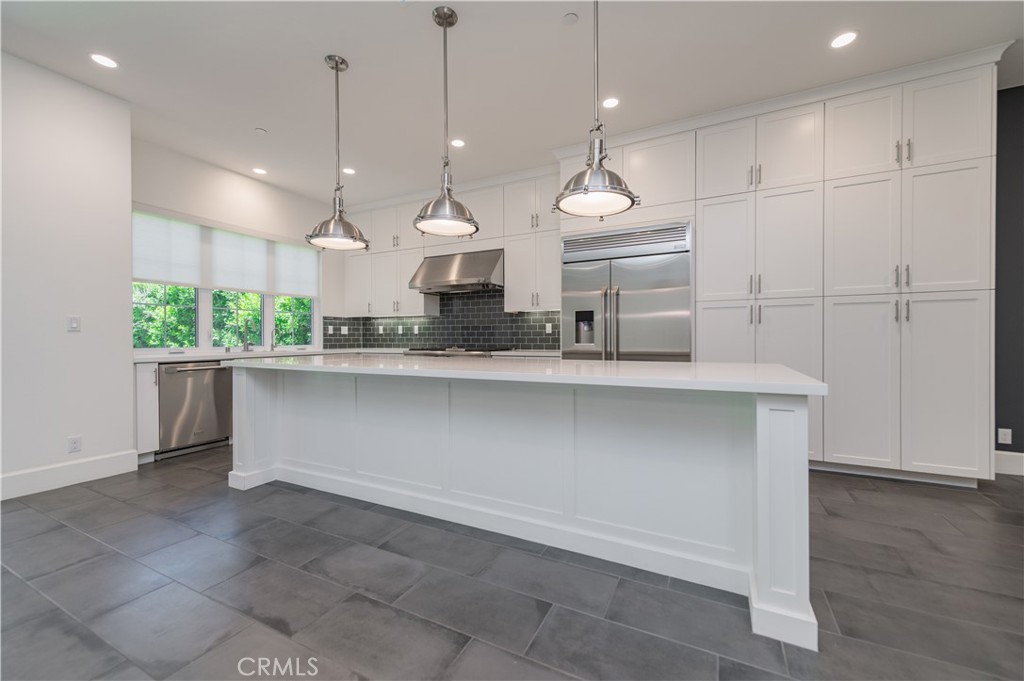 91 Rockinghorse Irvine, CA 92602 - Photo 9 of 48 a large kitchen with kitchen island a large counter top a sink and appliances