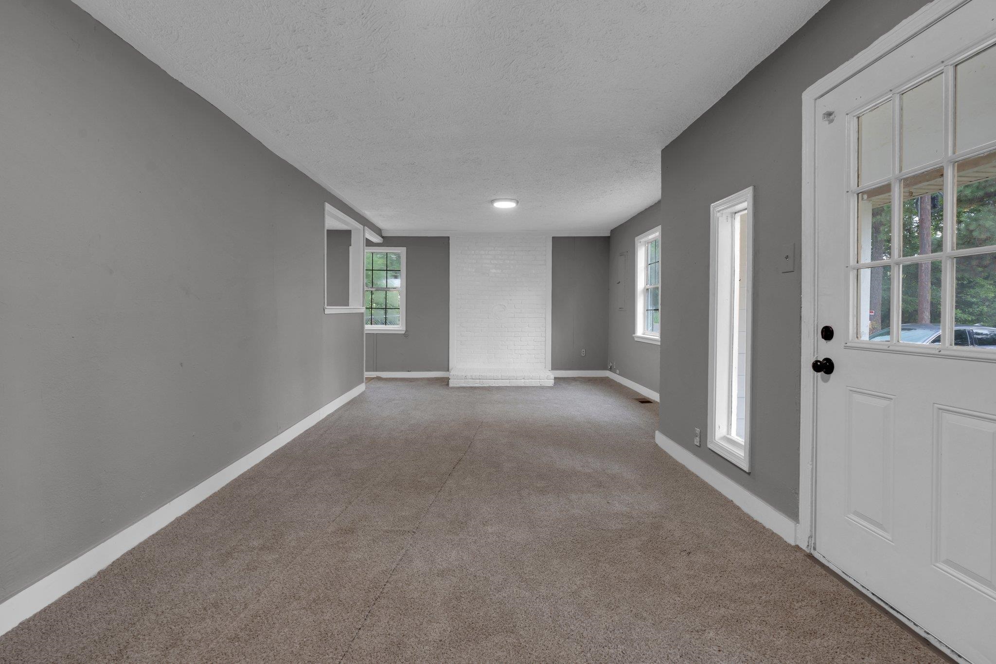 76 Bucksnort Road Covington, TN 38019 - Photo 4 of 21 Living Room featuring a textured ceiling, light colored carpet, and plenty of natural light