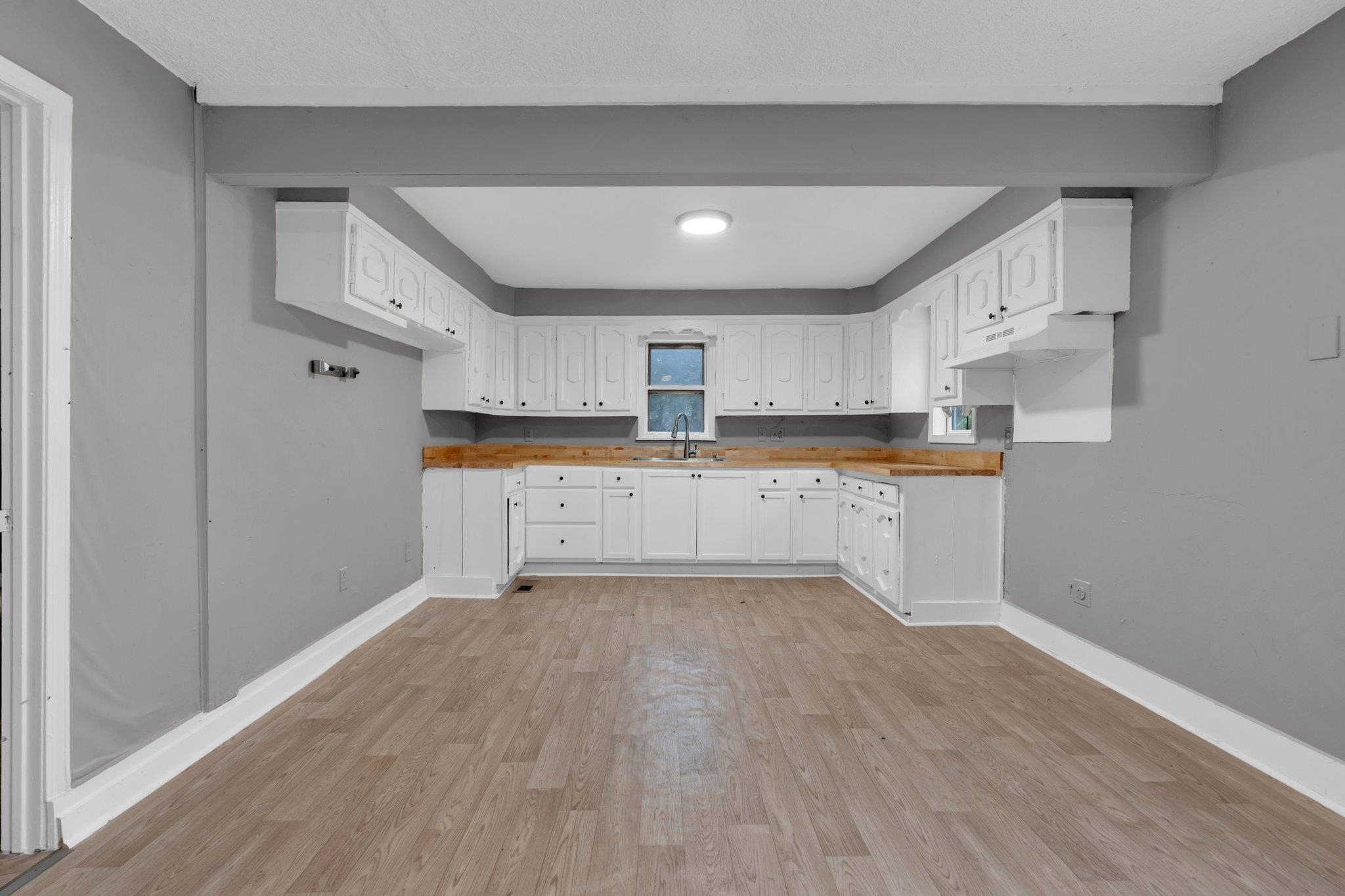 76 Bucksnort Road Covington, TN 38019 - Photo 8 of 21 Kitchen with sink, light hardwood / wood-style flooring, wooden counters, and white cabinets