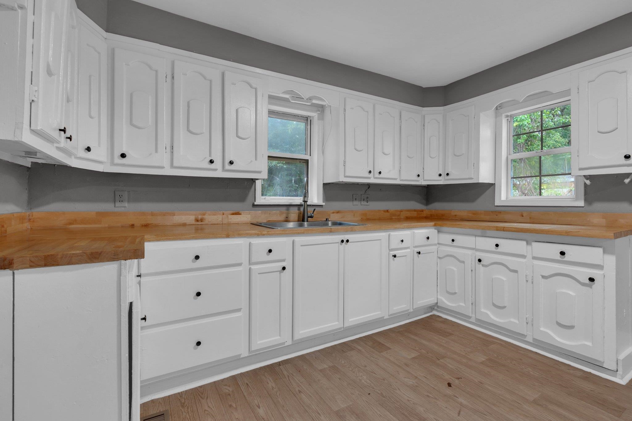 76 Bucksnort Road Covington, TN 38019 - Photo 9 of 21 Kitchen featuring white cabinets, plenty of natural light, sink, and wooden counters