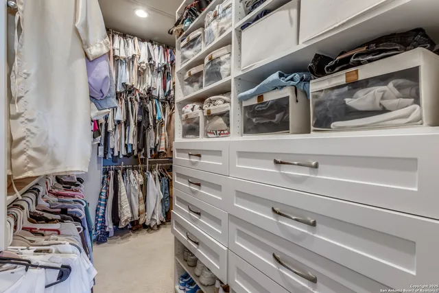 a view of walk in closet with clothes and shoes
