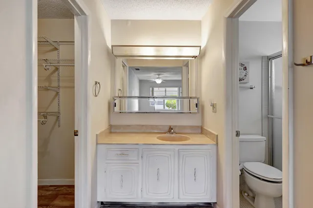 a bathroom with a granite countertop sink mirror and toilet