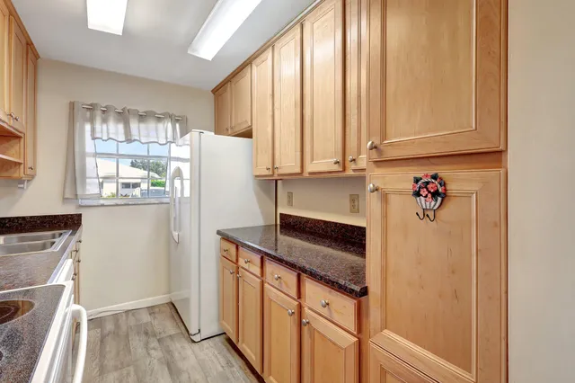 a kitchen with granite countertop a refrigerator and a stove top oven