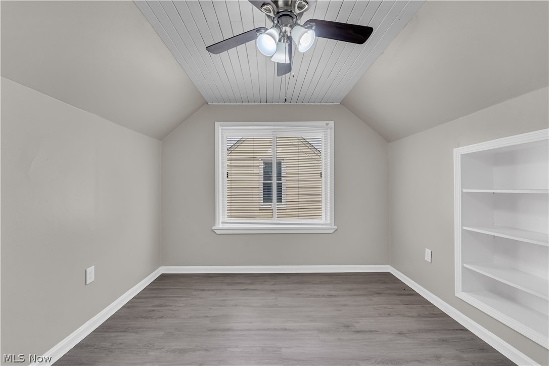 18517 Homeway Road Cleveland, OH 44135 - Photo 20 of 29 Attic room featuring wood-finish flooring, a built-in shelving unit, and a ceiling fan with integrated lighting