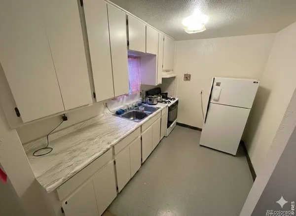 a kitchen with stainless steel appliances a stove a refrigerator and a sink