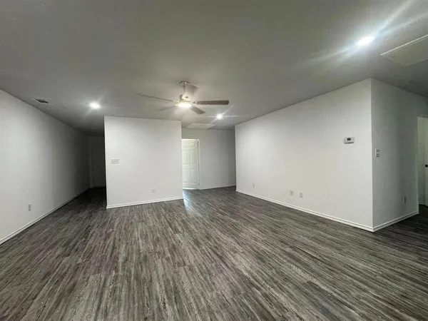 a view of an empty room with wooden floor
