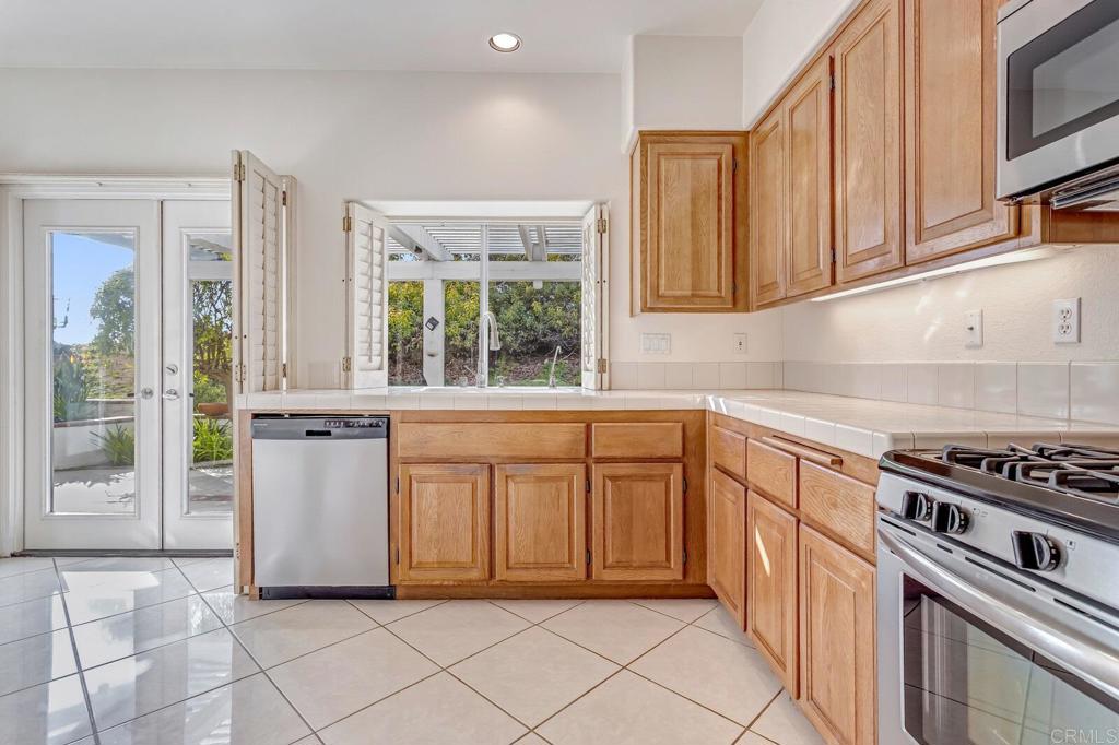 4144 Andros Way Oceanside, CA 92056 - Photo 11 of 29 a kitchen with white cabinets and appliances