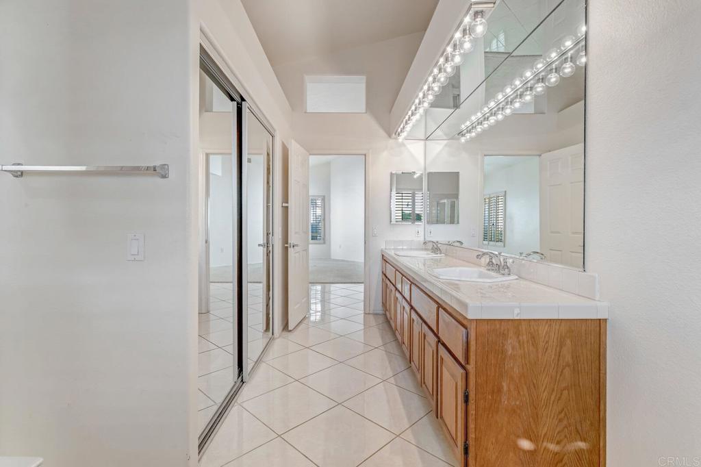4144 Andros Way Oceanside, CA 92056 - Photo 18 of 29 a bathroom with a double vanity sink mirror and shower