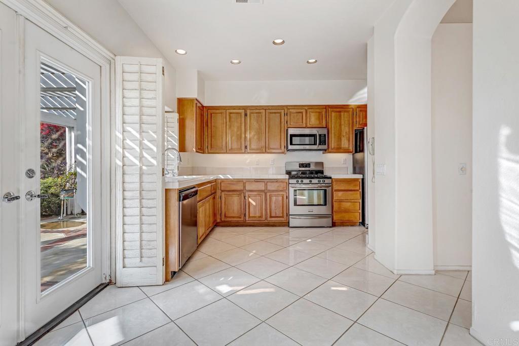 4144 Andros Way Oceanside, CA 92056 - Photo 9 of 29 a kitchen with stainless steel appliances granite countertop a stove a sink and a refrigerator