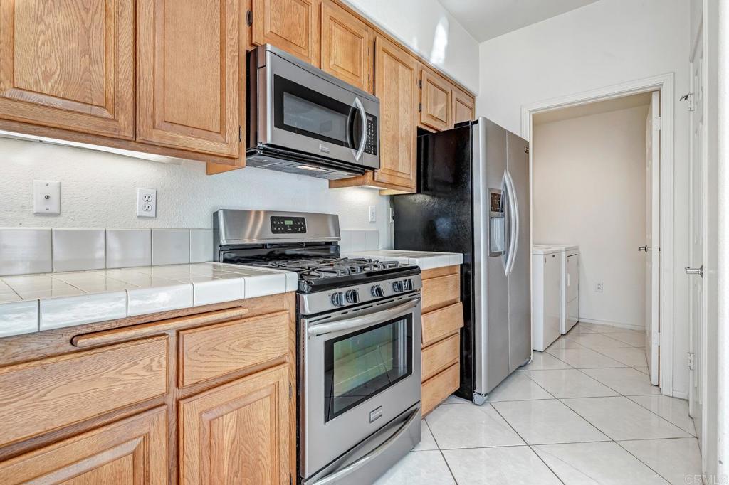 4144 Andros Way Oceanside, CA 92056 - Photo 10 of 29 a kitchen with stainless steel appliances granite countertop a stove microwave and refrigerator