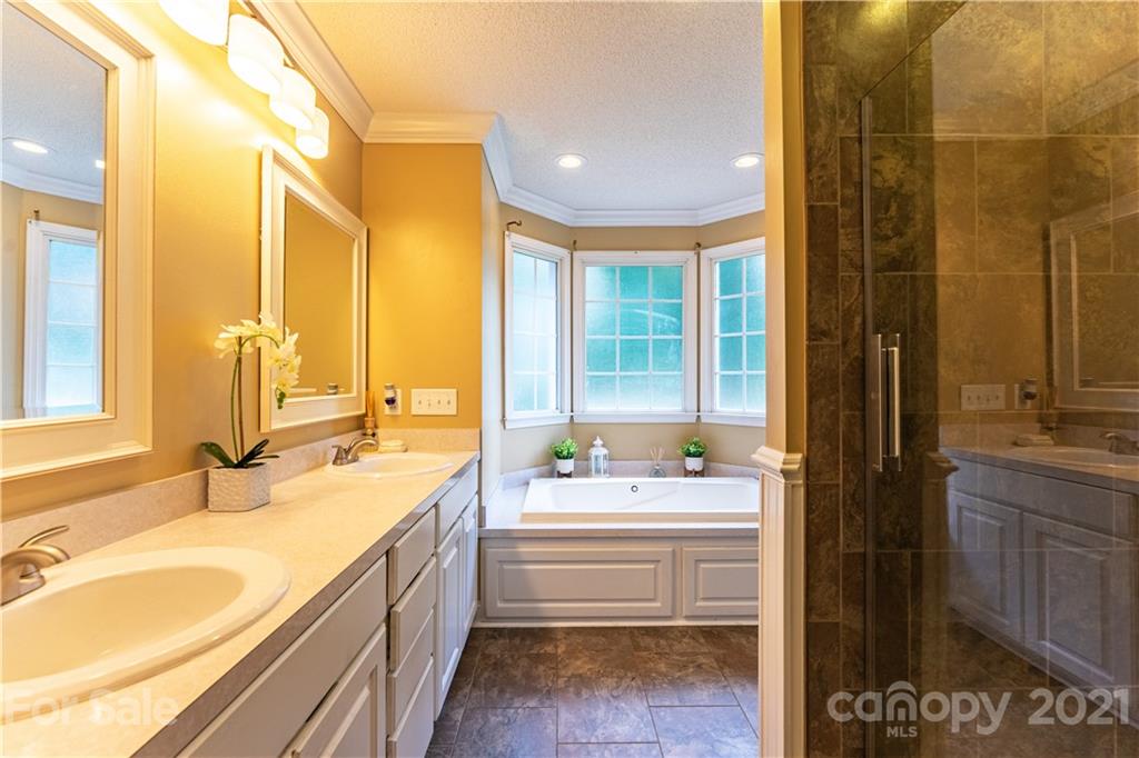 178 Buck Fraley Road Cherryville, NC 28021 - Photo 39 of 47 a bathroom with a double vanity sink a mirror and a bathtub