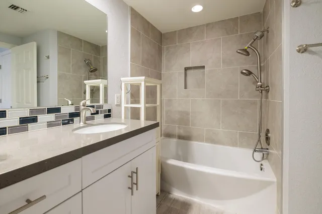 a white bath tub sitting next to a bathroom sink