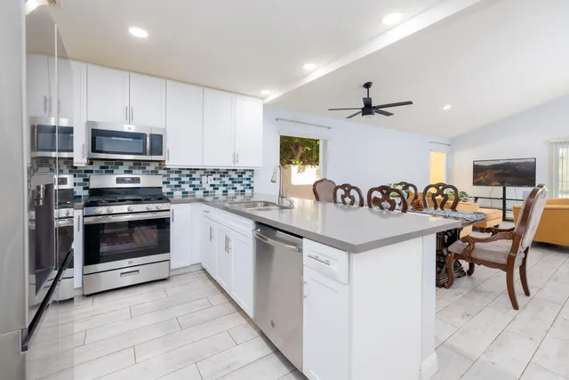 a kitchen with granite countertop a sink and a stove top oven with wooden floor