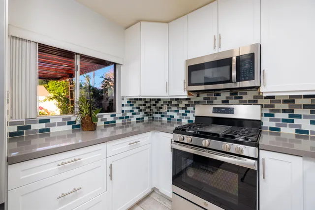 a kitchen with stainless steel appliances a stove a microwave a sink and cabinets