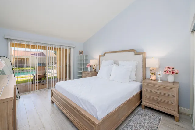 a bedroom with a bed a dresser and a large window