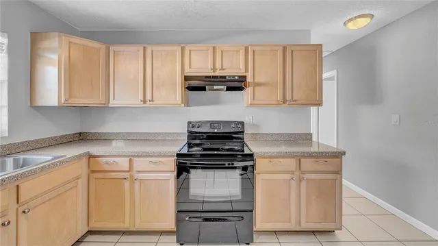 a kitchen with white cabinets and appliances