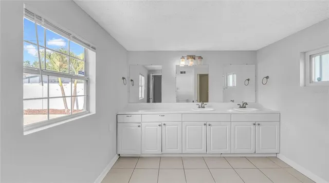 a spacious bathroom with a double vanity sink a mirror and a bathtub