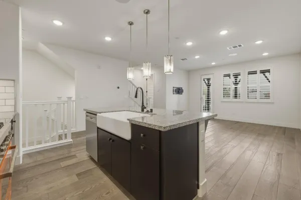 a kitchen with a sink chandelier and wooden floor