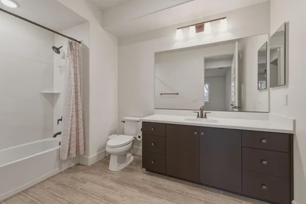 a bathroom with a double vanity sink toilet and shower