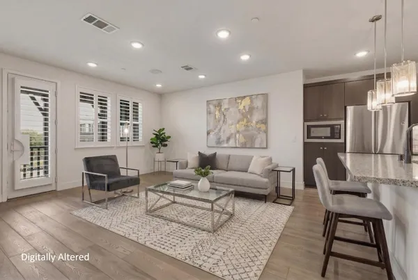 a living room with furniture wooden floor and a large window