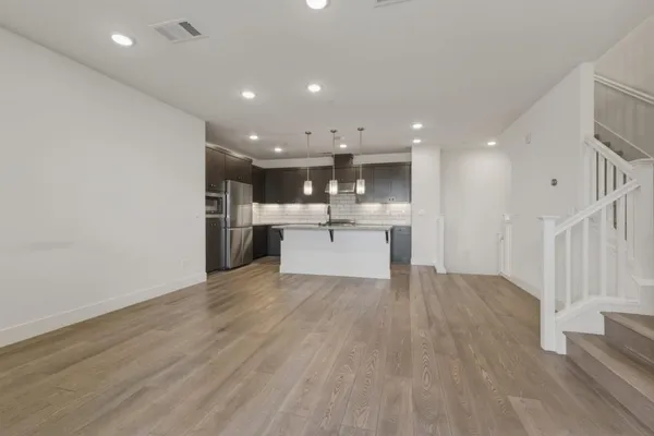 a view of a kitchen with a sink and wooden floor