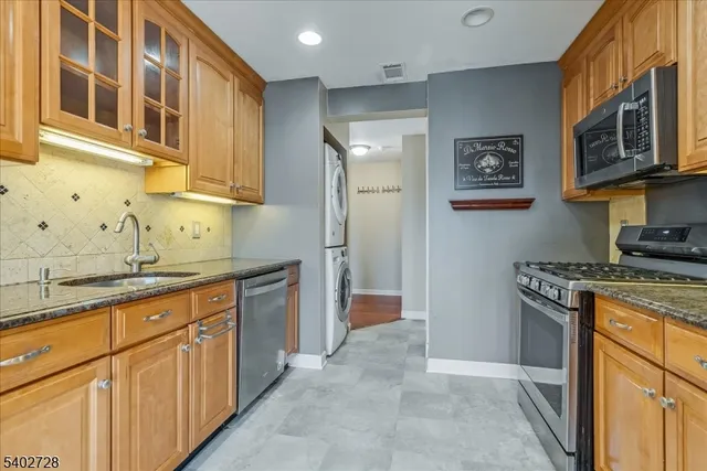 a kitchen with stainless steel appliances granite countertop a stove a sink and a refrigerator