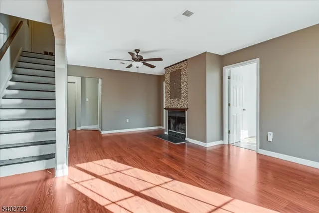 a view of empty room with wooden floor