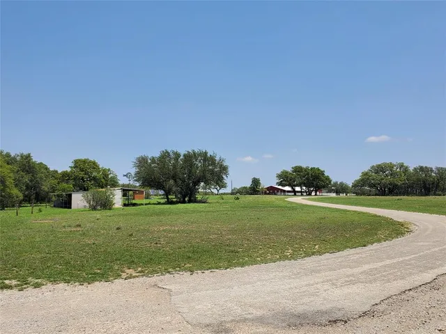 a grassy field with trees in the background
