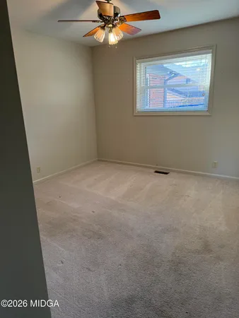 en empty room with windows and fan