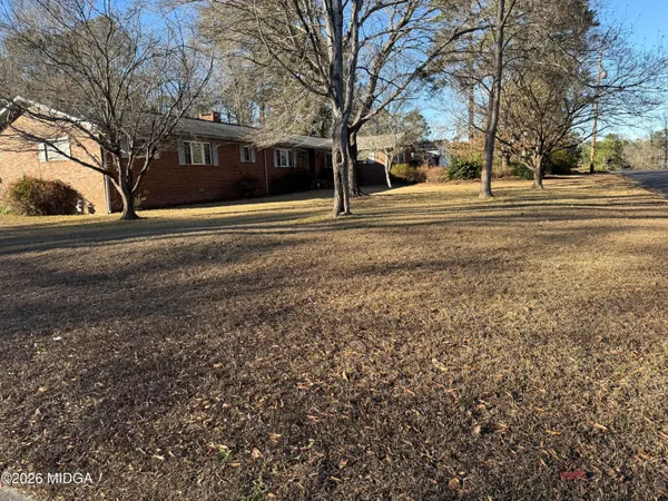 a front view of residential houses with yard and trees