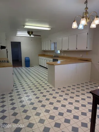 a kitchen with granite countertop a sink a stove top oven and cabinets