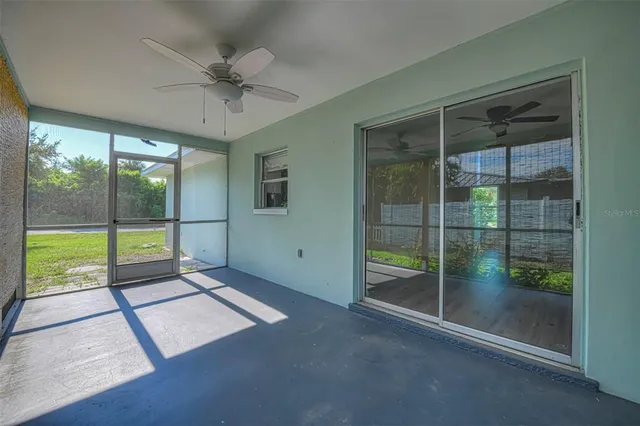 a view of an empty room and window ceiling fan