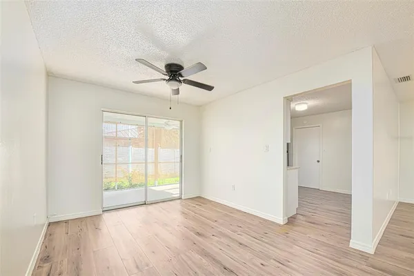 a view of an empty room with a window and wooden floor