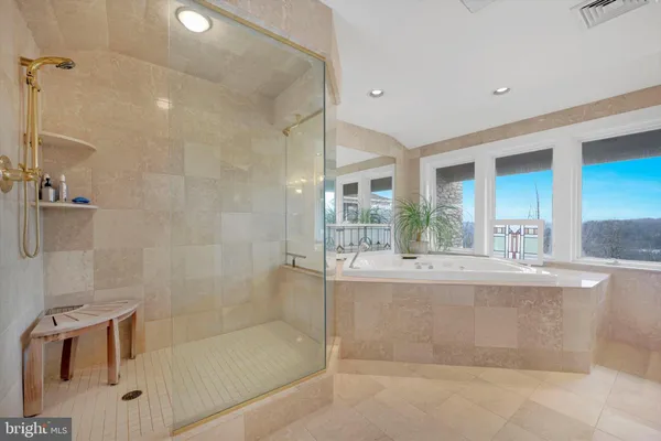 a bathroom with a tub a sink and glass door